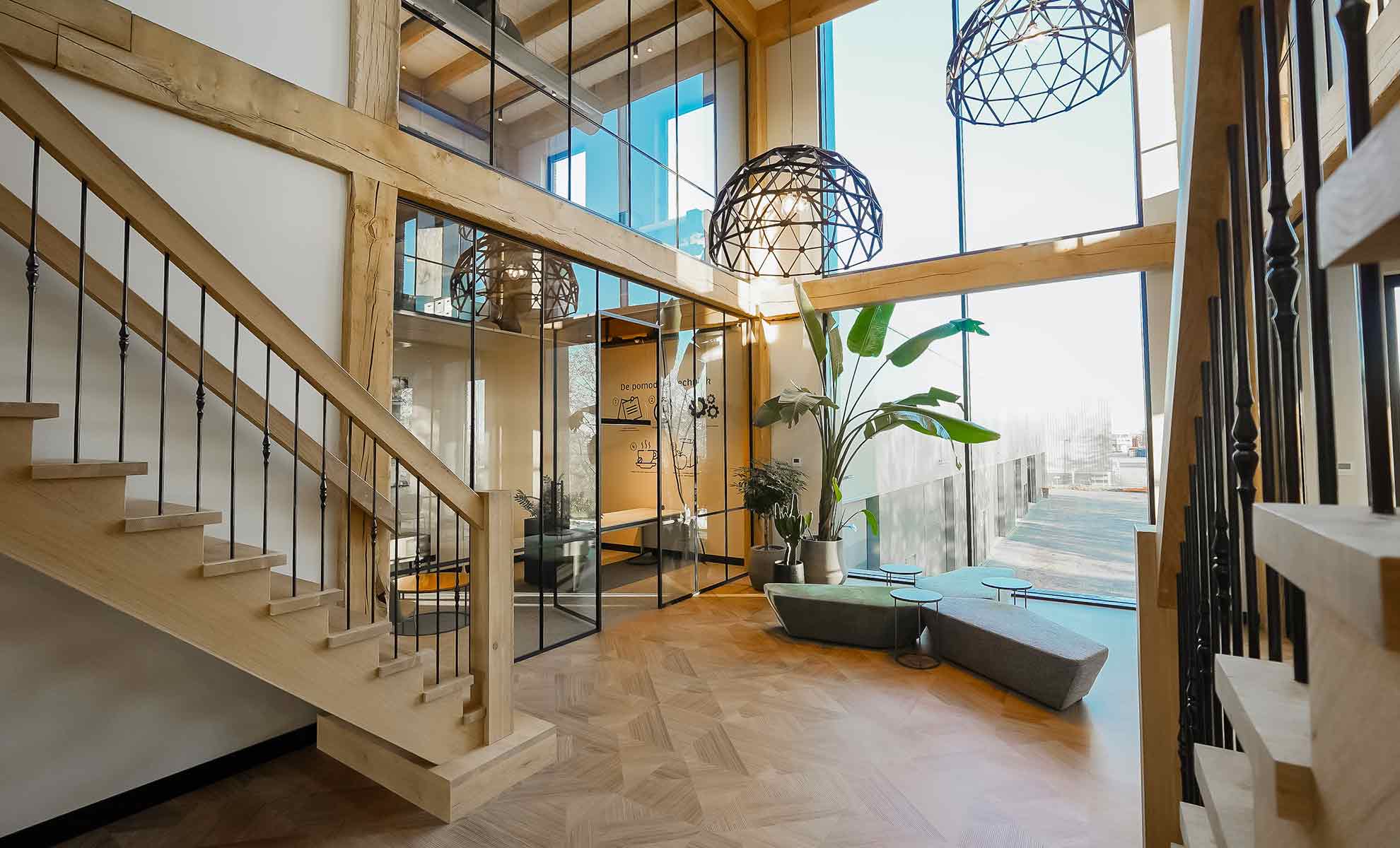 Glazen kantoorwanden in een vernieuwd kantoor met veel hout.