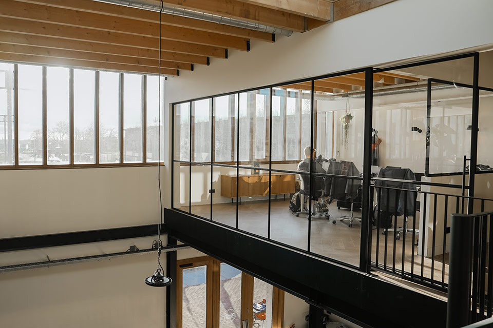 Glazen wand in een kantoor boven magazijn.